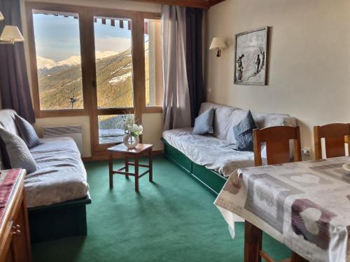 a living room with a couch and a window at Résidence le Rami Les coches in Les Coches
