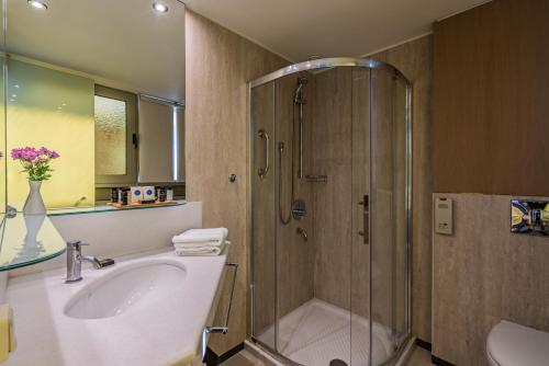 a bathroom with a shower and a sink at Kriti Beach Hotel in Rethymno Town