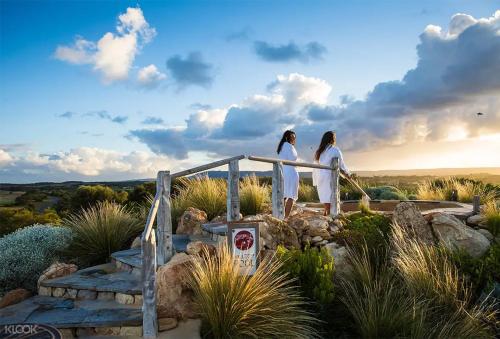 two women walking down a stairway with the sunset at Nautique Beach House - Rustic and Charming, Walk 2 Beach & Shops in Rosebud