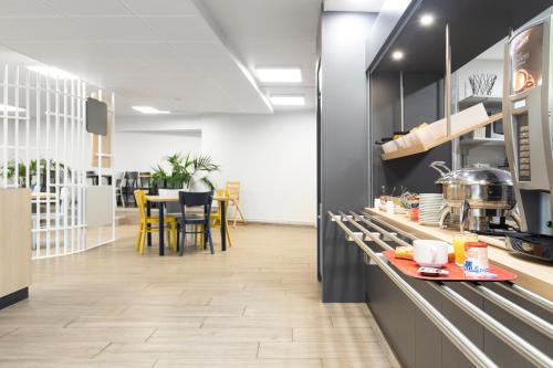 a kitchen with a counter and a table with chairs at B&B HOTEL Lyon Centre Monplaisir in Lyon