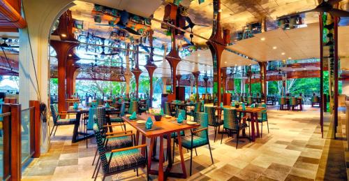 um restaurante com mesas e cadeiras em um prédio em Bunga Raya Island Resort & Spa em Gaya Island