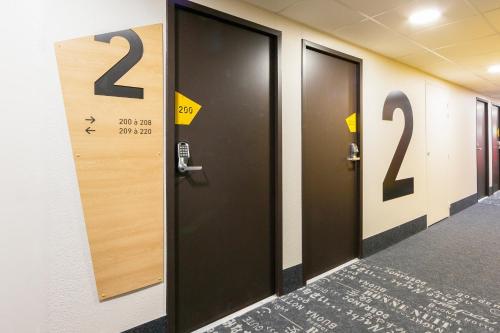 a row of doors in a hallway with numbers on them at B&B HOTEL Lyon Centre Monplaisir in Lyon