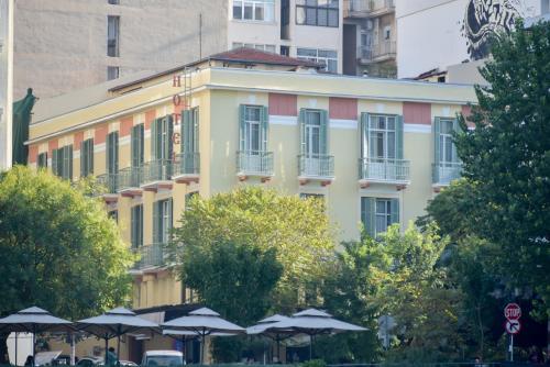 a yellow building with umbrellas in front of it at Orestias Kastorias in Thessaloniki