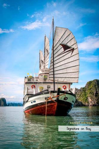 a boat with a sail in the water at Signature Halong Cruise in Ha Long