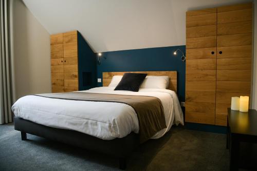 Appart'Hotel Aiguille Verte & Spa في شامونيه مون بلان: غرفة نوم بسرير كبير بجدار ازرق