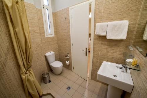 a bathroom with a sink and a toilet and a shower at Orestias Kastorias in Thessaloniki