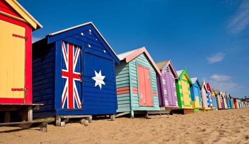 a row of colorful beach huts on the beach at Nautique Beach House - Rustic and Charming, Walk 2 Beach & Shops in Rosebud