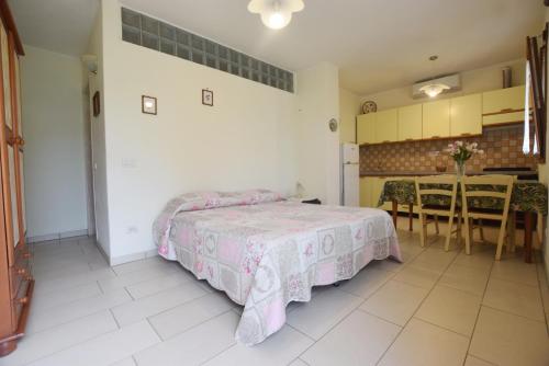 a bedroom with a bed and a dining room with a table at Margherita Monolocale in Marina di Campo