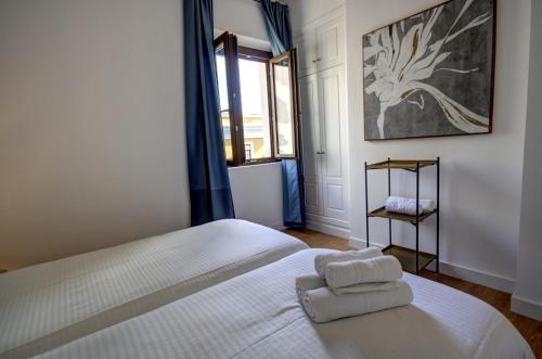 a bedroom with a bed with two towels on it at Apartamentos Setas Center in Seville