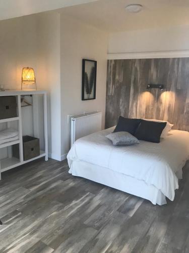 a bedroom with a white bed and wooden floors at Wildwood Lodge in Carlingford