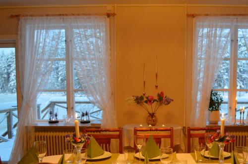 a dining room with a table and two windows at River Lodge in Ludvika