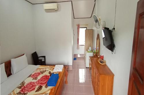 a bedroom with a bed and a tv on a wall at Happy Lagoon Bungalow in Khao Lak