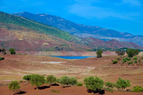 a river in the middle of a desert with mountains at Les Jardins Yasmina Bin el-Ouidane in Bine el Ouidane