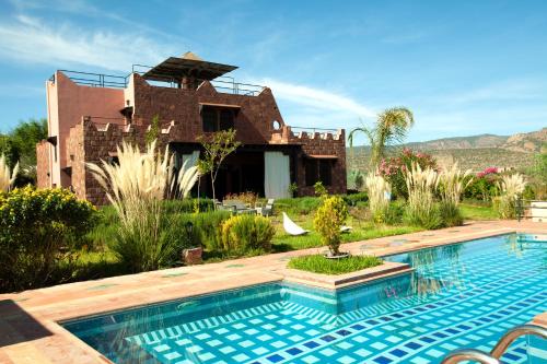 a house with a swimming pool in front of a house at Les Jardins Yasmina Bin el-Ouidane in Bine el Ouidane