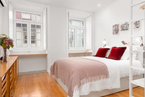 a white bedroom with a bed with red pillows at Oporto Classic Pàtio in Porto