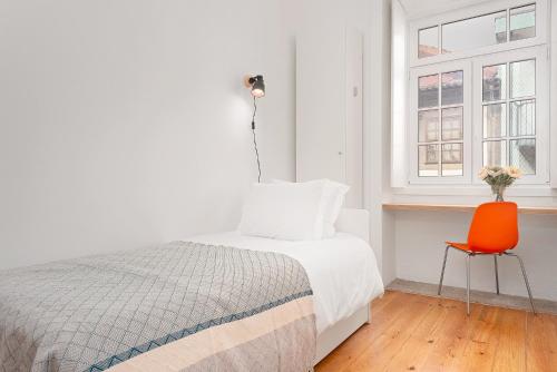 um quarto com uma cama e uma cadeira laranja em Oporto Classic Pàtio em Porto