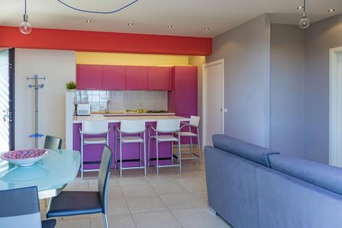 a kitchen with a blue table and purple cabinets at Casa e Mare in Montignano