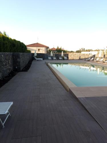 a large swimming pool with a bench next to it at B&B nna'vigna in Viagrande