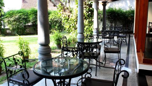 a group of tables and chairs on a patio at The Mascot Hotel - A Heritage Living Experience in Trivandrum