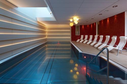 uma piscina com cadeiras num quarto em Hotel Zum Mohren em Reutte