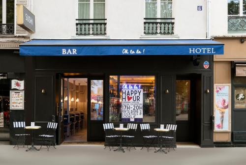 a bar with chairs and tables in front of a building at Oh la la ! Hotel Bar Paris Bastille in Paris