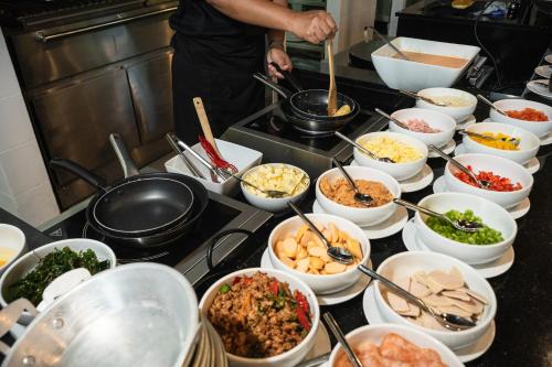 a kitchen with many bowls of food on a counter at Hotel Labaris Khao Yai in Mu Si