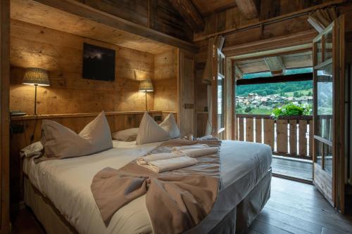 1 dormitorio con 1 cama grande en una habitación con ventana en Hotel Chalet Svizzero, en Courmayeur