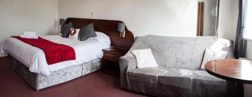 a hotel room with a bed and a chair at Oliver Twist Country Inn in Wisbech