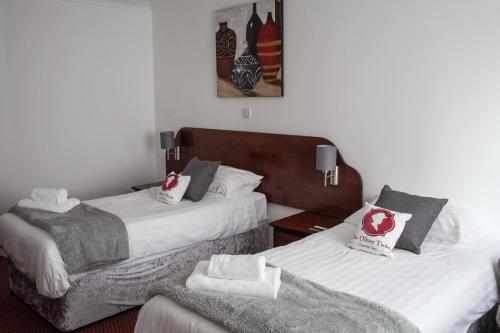 Habitación de hotel con 2 camas y toallas. en Oliver Twist Country Inn en Wisbech