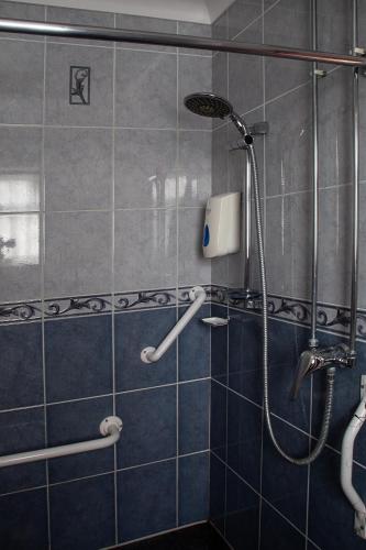 a bathroom with a shower with blue tiles at Oliver Twist Country Inn in Wisbech