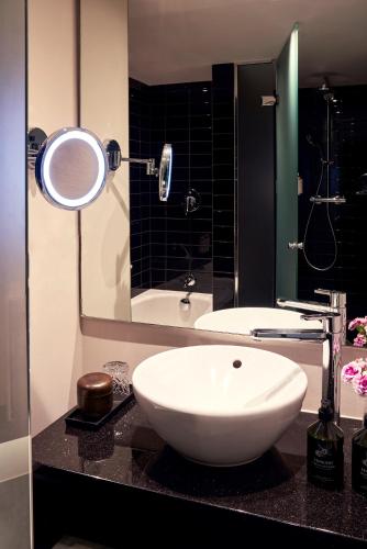 a bathroom with a white sink and a mirror at Park Centraal Amsterdam, part of Sircle Collection in Amsterdam
