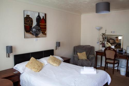 a hotel room with a bed and a desk and a desk at Oliver Twist Country Inn in Wisbech