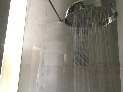 een douche met een douchekop en een douchegordijn bij Zaira House in Marciana