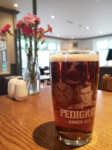 a glass of beer sitting on a table at The Coach House Inn in Chester