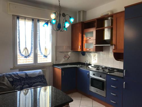 cocina con armarios azules y fogones en Appartamento Fano zona lido, en Fano