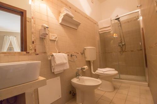 uma casa de banho com um lavatório, um WC e um chuveiro em Antica Masseria Rottacapozza em Torre San Giovanni Ugento