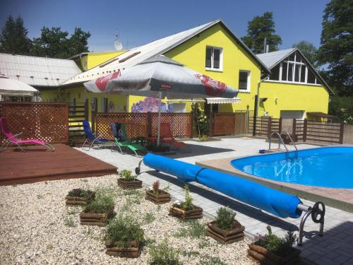 a backyard with a pool and a house with a swimming pool at Penzion Krásný Dvůr in Krásný Dvŭr