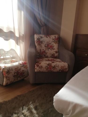 a chair sitting in a bedroom with a window at Balneo and SPA Complex MINERAL YAGODA in Yagoda