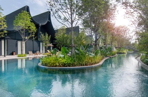 a pool in the middle of a house with trees and plants at Hotel Labaris Khao Yai in Mu Si