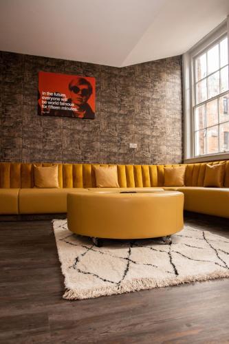 a living room with a yellow couch and a rug at York Street Studios in Liverpool