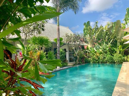 a pool in the middle of a garden with plants at Hari Indah Boutique Hotel & Spa in Uluwatu