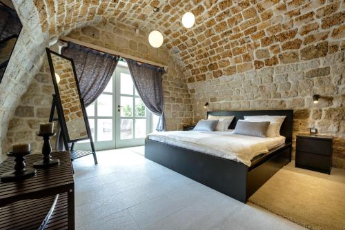 een slaapkamer met een bed in een bakstenen muur bij Villa Pugliesi in Zaton