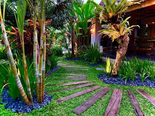 a garden with palm trees and blue rocks at Hari Indah Boutique Hotel & Spa in Uluwatu