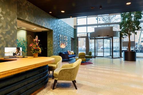 a lobby with a counter and chairs in a building at Citadines Sloterdijk Station Amsterdam in Amsterdam