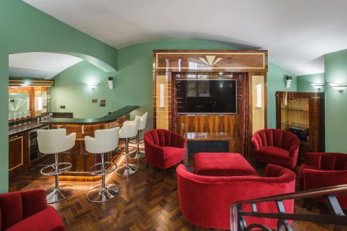 a living room with red chairs and a bar at Sea-facing Art Deco Apartment in Brighton & Hove