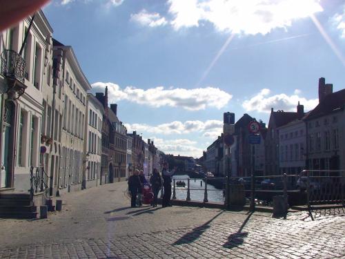 a group of people walking down a street next to a canal at Apartment Het Blekershuys in Bruges