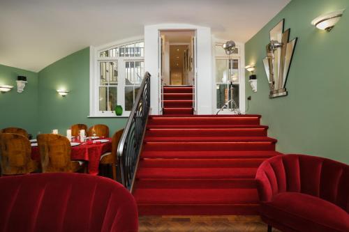 a stairway with red chairs and a table and stairs at Sea-facing Art Deco Apartment in Brighton & Hove
