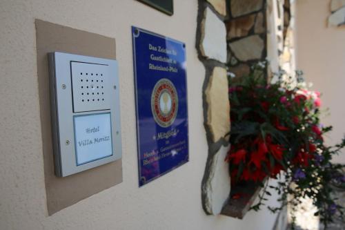 a sign on a wall next to a vase of flowers at Landhotel Villa Moritz garni in Oberahr