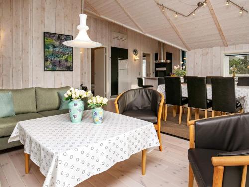 a dining room with a table with flowers on it at 6 person holiday home in Thisted in Thisted
