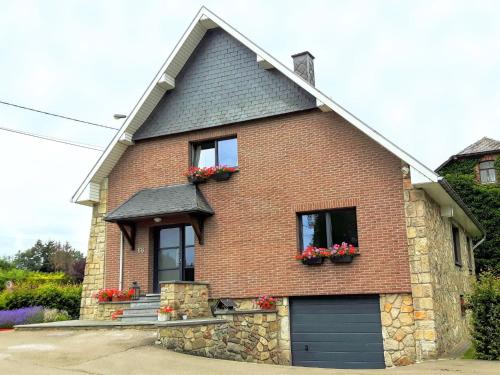 a brick house with flower boxes on the windows at Alluring Holiday Home in Waimes with Garden in Waimes